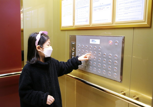 4월 1일 금천구의 한 아파트단지에서 어린이가 항균필름이 부착된 승강기 버튼을 누르고 있다.