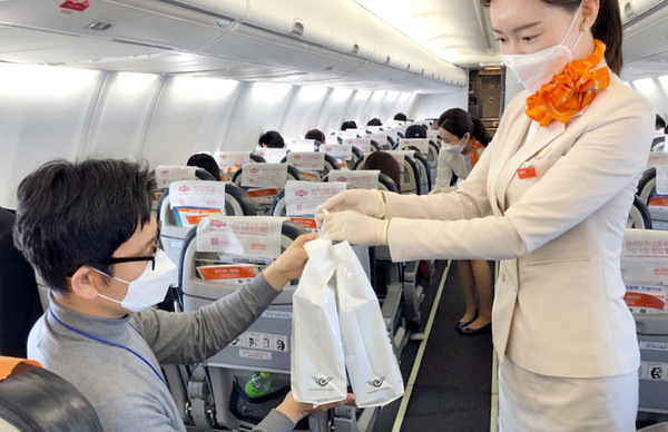 제주항공이 12일 일본 상공을 비행하고 돌아오는 무착륙 국제 관광비행을 실시했다. 이날 한 탑승객이 기내에서 면세품을 사고 있다. [제주항공 제공]