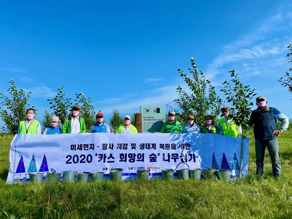 2020년 8월 몽골 에르덴솜 지역에 위치한 ‘카스 희망의 숲’ 일대에서 하늘마을 주민들이 포플러 나무를 식재하고 기념사진을 찍고 있다. [오비맥주 제공]