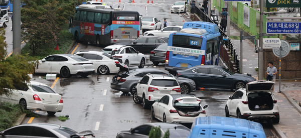 9일 오전 서울 서초구 진흥아파트 앞 서초대로 일대에서 전날 내린 폭우에 침수됐던 차량이 모습을 드러내고 있다. [연합뉴스]