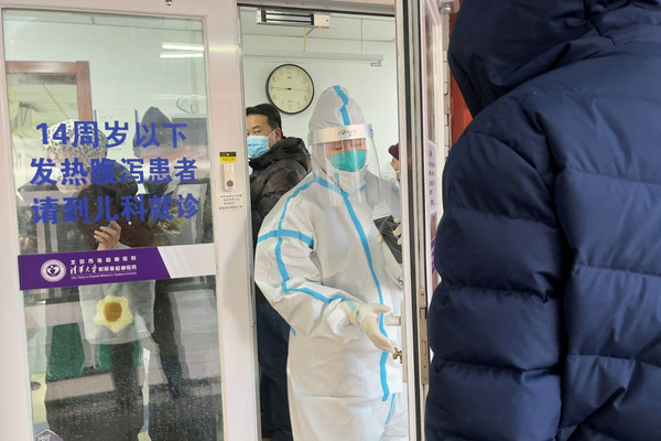 15일 중국 베이징의 한 병원 발열 진료소에 시민들이 방호복을 입은 직원 옆에 줄을 서 있다. [베이징 로이터=연합뉴스]