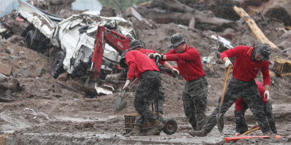 18일 오후 경북 예천군 감천면 진평2리에서 폭우가 쏟아지는 가운데 해병대 1사단 장병들이 산사태 피해 복구에 힘쓰고 있다.  [연합뉴스]