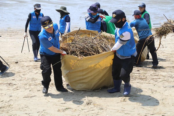 충남 보령해양경찰서는 최근 집중호우시 금강에서 떠밀려온 쓰레기 제거를 위해 서천군 띠섬목해변에서 피해 복구 활동을 실시했다. [보령해경 제공]