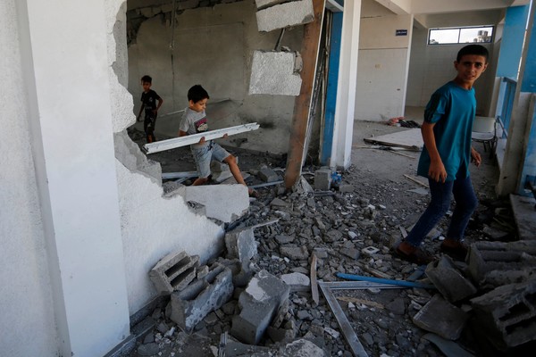 아이들이 18일(현지시간) 공습으로 파괴된 가자지구 중부의 알 마가지 난민 캠프를 둘러보고 있다. [가자지구 AFP=연합뉴스]