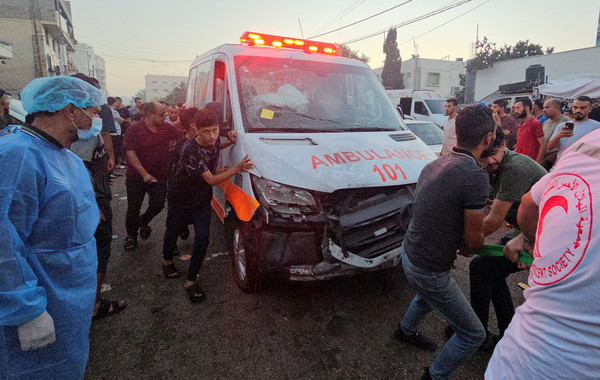 지난 3일(현지시간) 가자시티 알시파 병원 입구에서 팔레스타인인들이 공습으로 파손된 구급차를 끌고 있다. 가자지구 보건부는 이날 중상자를 이송하던 구급차 행렬이 공습을 받아 15명이 숨지고 60여명이 다쳤다고 주장했다. [가자시티 로이터=연합뉴스]