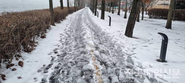 강변도로 위쪽 보행자 도로의 눈이 녹아 얼어붙은 현장.