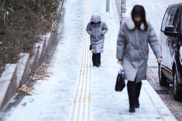 많은 눈이 예보된 9일 오전 서울 중구 을지로입구역 인근에서 시민들이 눈이 쌓인 오르막길을 걷고 있다. [연합뉴스]