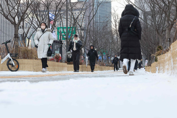 아침 최저기온이 영하 10도까지 떨어지며 강추위가 찾아온 22일 오전 서울 종로구 광화문네거리에서 두꺼운 옷차림을 한 시민들이 이동하고 있다. [연합뉴스]