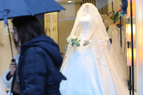 서울 마포구 아현동 웨딩거리 한 웨딩드레스 판매점 앞을 시민들이 지나가고 있다. [연합뉴스]