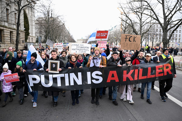 지난 18일(현지시간) 독일 베를린의 러시아 대사관 인근 거리에서 러시아 반체제 운동가 알렉세이 나발니의 의문사에 항의하는 시위대가 '푸틴은 살인자'라는 문구가 적힌 현수막을 들고 행진하고 있다. [베를린 로이터=연합뉴스]
