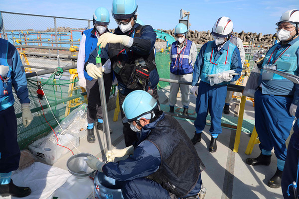 지난해 10월 3일(현지시간) 일본 후쿠시마현 오쿠마에서 관계자들이 후쿠시마 제1원자력발전소 오염수(일본 정부 명칭 '처리수')의 샘플을 채취하고 있다. [도쿄전력 제공]