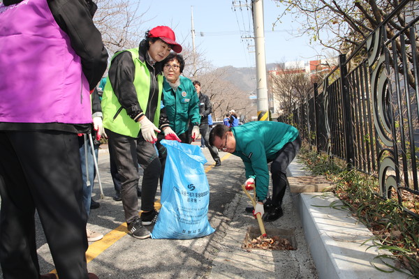 창원시가 18일 봄맞이 대청소를 시행한 가운데, 홍남표 창원시장도 지역 주민들과 함께 도로 가에 쌓여 있는 빗물받이를 열어 낙엽과 담배꽁초를 수거하는데 적극적으로 동참했다. [창원시 제공]