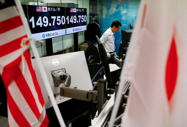 19일 일본은행이 8년간의 마이너스 금리를 종료했다는 보도가 나온 후 한 외환 거래 회사에서 직원이 모니터 옆에 서 있다. [로이터=연합뉴스]