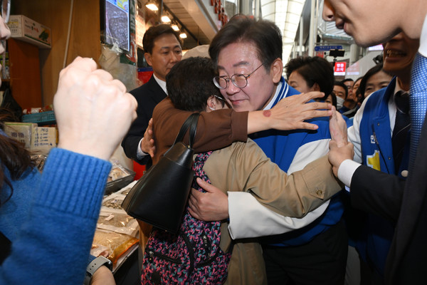 더불어민주당 이재명 대표가 24일 서울 송파구 잠실 새마을전통시장에서 한 지지자와 포옹하고 있다. [연합뉴스]