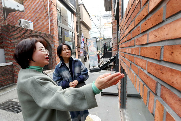 성동구 한 건축사무소 대표(좌)와 성수동 주민이 붉은벽돌 건축물을 살펴보고 있다.[성동구 제공]