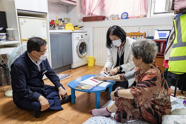 김경호 구청장(맨 왼쪽)이 어르신 가정을 방문해 혈압을 체크해 보고 있는 모습을 지켜보고 있다. [광진구 제공]