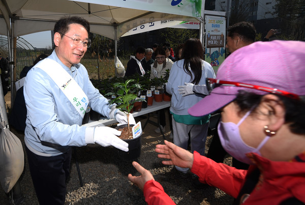 유정복 인천시장이 지난 5일 선학 어반포레스트에서 열린 ‘제79회 식목일 나무심기 행사’에서 시민들에게 ‘2025 아시아태평양경제협력체(APEC) 정상회의’ 유치 희망나무를 나눠주고 있다. [인천시 제공] 