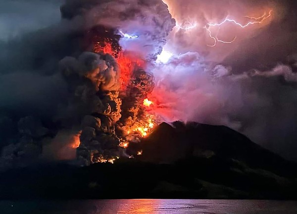 17일(현지시간) 인도네시아 북술라웨시주 루앙 화산이 검은 연기와 용암을 뿜어내며 분화하고 있다. [인도네시아 AFP=연합뉴스]