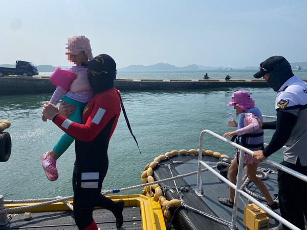 구조된 어린이 2명을 선착장으로 데려오는 보령해경.