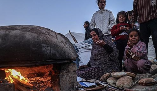 이슬람 금식성월 라마단 첫날인 11일(현지시간) 팔레스타인 가자지구 남부 라파에서 금식을 깨는 저녁 식사 이프타르 전 한 팔레스타인 피란민 여성이 빵을 굽고 있다. [라파 AFP=연합뉴스]