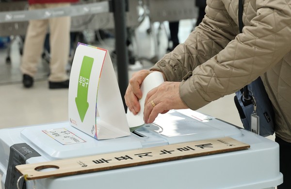 투표함에 투표지 넣는 유권자. [연합뉴스]