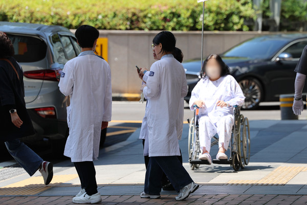 의대 정원 증원을 두고 의정갈등이 이어지는 가운데 8일 오전 서울 시내 한 대학병원에서 의료진이 이동하고 있다. [연합뉴스]